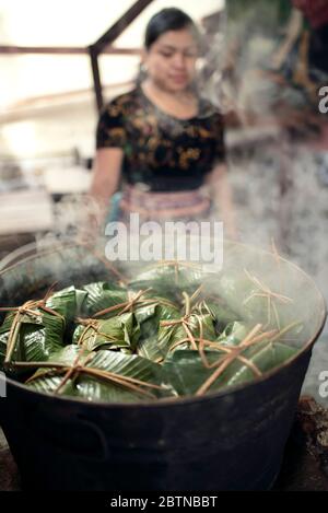 Tamales (Maisschale, Chili und Fleisch in Bananenblättern verpackt) Kochen in einem großen Topf. Weihnachtstradition am Atitlán-See, Guatemala. Dez 2018 Stockfoto