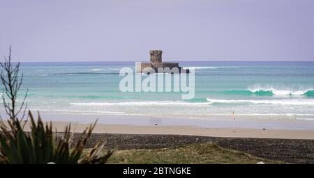 Ruhiges, blaues Meer und Blick auf den La Rocco Tower, St Ouen's Beach, Jersey Channel Islands, Großbritannien Stockfoto