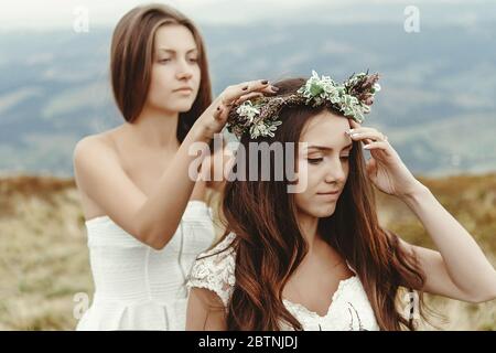 Stilvolle Brautjungfer helfen wunderschöne Braut Vorbereitung, Boho Hochzeit, Luxus-Zeremonie in den Bergen Stockfoto