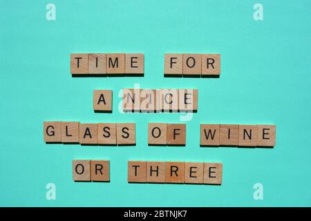 Zeit für EIN schönes Glas Wein oder drei, Wörter in hölzernen Buchstaben, isoliert auf türkisfarbenem Hintergrund Stockfoto