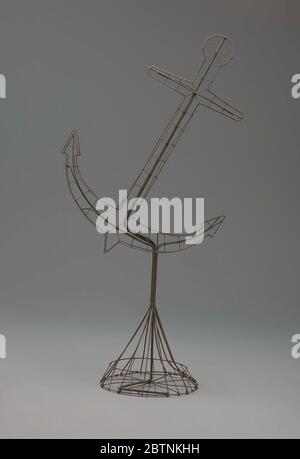 Anker für Drahtrahmen am Ständer. Die Anordnung der Ankerblumen war schwierig zu arrangieren. Es erforderte enge Arbeit und präzise Umrippe, oder die Form des Blumenrahmens würde verloren gehen. Es war angebracht, zur Beerdigung von Männern oder Frauen jeden Alters zu senden. Stockfoto