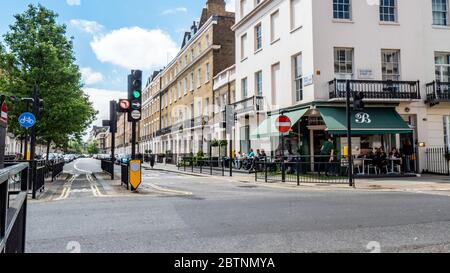 Belgravia Straße Szene. Georgianische Architektur im exklusiven Viertel West London; La Bottega Eccleston ist ein beliebtes italienisches Café bei den Einheimischen Stockfoto