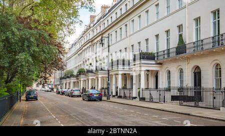 Belgravia, London. Eine sonnige Straßenszene, die die georgianische Architektur zeigt, die typisch für das wohlhabende und exklusive Viertel von West London ist. Stockfoto