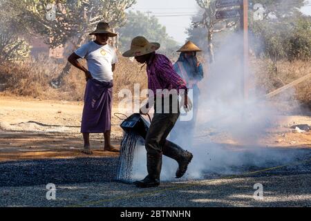 Lokale Männer Resurfacing A Road, Bagan, Mandalay Region, Myanmar. Stockfoto