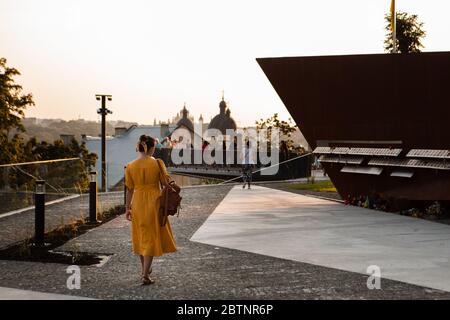 Frau in gelber Sonnenkleid, die durch die Stadt unterwegs ist Stockfoto