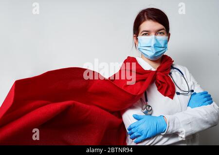 Arzt trägt chirurgische Gesichtsmaske in Superhelden Umhang. Konzept des Superheldentums medizinisches Personal während des Coronavirus-Ausbruchs. Stockfoto