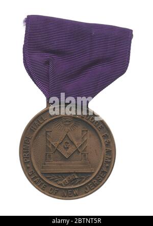 Medaille zum 100. Jahrestag der Prince Hall Grand Lodge von New Jersey. Eine Gedenkmedaille zum 100. Jahrestag der Prince Hall Grand Lodge in New Jersey. Die Medaille ist rund und bronzefarben mit einem Balken oben, durch den ein lila Band durchgeschleift wurde. Das Band wird auch durch eine Pinback-Verschluss geloopt. Stockfoto