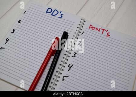 Do's und Don't's schreiben isoliert auf Holztisch. Stockfoto