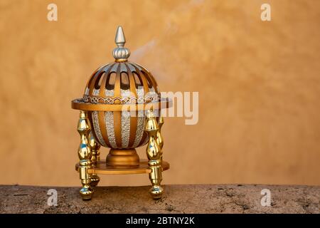 Omanischer Räucherofen, der auf einer Wand in Nizwa Fort sitzt und dampft Stockfoto