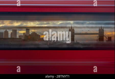 Tower Bridge und Canary Wharf haben durch die Fenster eines schnell fahrenden Londoner Busses gedreht und das Bild in Bewegungsunschärfen-Bändern erzeugt. Stockfoto