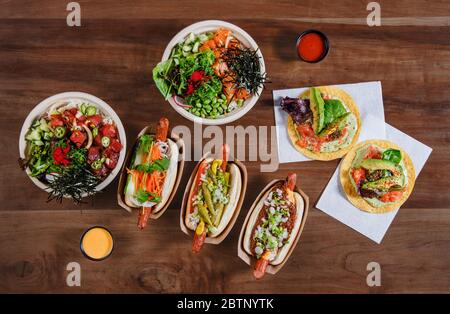 Hawaiianische Essensausschl mit Poke Bowls, Hot Dogs und Fisch Tacos Stockfoto