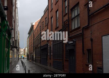 Blick auf eine Gasse in Richtung Turm im Zentrum von Dublin an einem bewölkten Tag Stockfoto