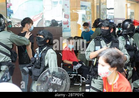 Hongkong Hongkong, S.A.R. China - 27 Mai, 2020 Abgebildet, Polizeikräfte der Hongkonger Polizei Riot-Trupps halten an und suchen einen älteren behinderten Mann im zentralen Finanz- und Geschäftsviertel von Hongkong, da die Spannungen in der Stadt seit der Ankündigung des Nationalhymne-Gesetzes und während der Lesung der Nationalhymne-Gesetzesvorlage aufflackert. Simon Jankowski/Alamy Live News Stockfoto