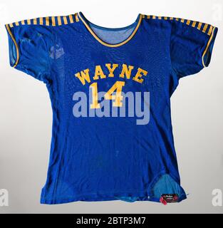 Basketball Trikot für Lockland Wayne High School. Dunkelblaues elastisches Kurzarm-Hemd, auf dem gelbe Schriftzüge mit der Aufschrift genäht wurden [WAYNE / 14]. Goldene und blaue Bänder verlaufen beide Schultern vom Hals bis zum Ende der Ärmel hinunter. Goldfarbene und blaue Zierleiste an den Ärmelöffnungen. Auf der Rückseite Gold [14] auf der oberen Rückseite genäht. Stockfoto