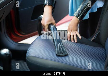 Frau Reinigung, Staubsaugen Innenraum des Autos mit Staubsauger, Transport-Konzept Stockfoto