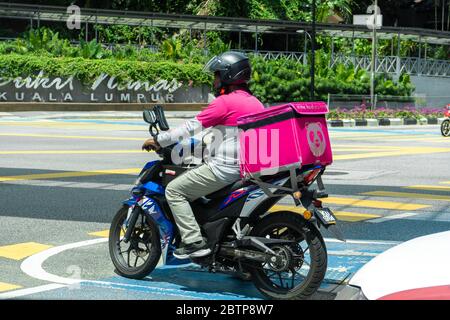 Kurier eines beliebten Lebensmittel-Lieferservice in Malaysia auf einem Fahrrad. Essen bestellen zu Hause. Stockfoto