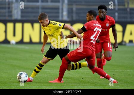 Der Münchner David Alaba, Mitte, und Alphonso Davies, rechts, fordern den Ball mit Dortmunds Thorgan Hazard, links, während des Bundesligaspieles zwischen Borussia Dortmund und dem FC Bayern München in Dortmund. Stockfoto