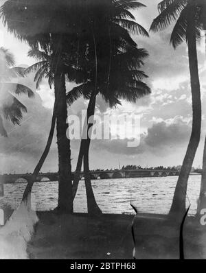 Ein Sonnenuntergang in Florida. Brechen durch die abgesenkten Wolken nach einem Regensturm, die untergehende Sonne schafft diese schöne Szene am Palm Beach, Florida. Die Brücke im Hintergrund trennt Palm Beach von West Palm Beach. 23. Januar 1932 Stockfoto