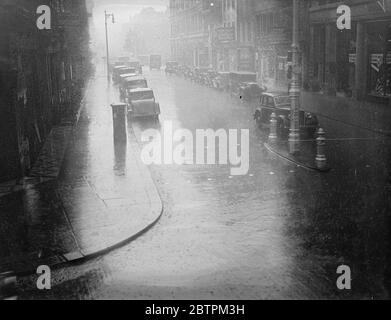 London überschwemmte Londoner wurden geschickt, um Schutz zu suchen, wenn Regen in Strömen hinunterfegte. Foto zeigt: EINE Szene vor der Regent Street während des Regensturms. Juli 1936 Stockfoto