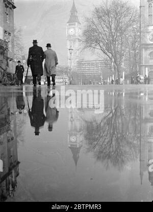 Spiegel der Zeit. Die Abendsonne, die nach dem starken Regen auf den nassen Gehwegen von Westminster scheint, spiegelt Big Ben wie durch in einem riesigen Spiegel wider. 25 Februar 1937 Stockfoto