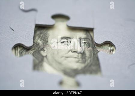 Fragment des Porträts amerikanischer Präsident Benjamin Franklin von einem hundert Dollar Banknotenschein. Blick durch den fehlenden Teil der Puzzles. Econom Stockfoto
