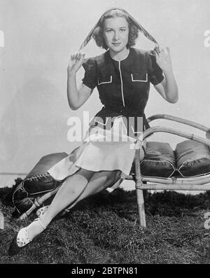 Das „sehr satile“ Taschentuch. Shirley Ross, die Hollywood-Filmschauspielerin, mit einem bunt gefärbten Quadrat aus hellem Blau, Rot und Grau, das mit einer Navy- und Graulinie Sportfront getragen wird, kann sein Taschentuch um den Hals geknüpft, in eine Tasche gesteckt oder verdreht und um die Haare gebunden werden Stockfoto