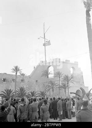 Libyscher Markt. Der faschistische Gruß, jeden Abend bei Sonnenuntergang, das Leben der geschäftigen Stadt hält tot für eine Minute. Eine Waffenschau kündigt der Bevölkerung das Abschleppen der italienischen Farben von der Spitze des Schlosses von Tripolis an. Foto zeigt die Szene auf dem Schloss. Stockfoto