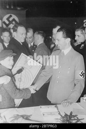 Dr. Goebbel'-Santa Claus. Dr. Goebbels, Nazi-Propagandaminister, lächelte breit, als er einem jungen Gast die Hände schüttelte, nachdem er in Berlin ein Weihnachtsgeschenk überreicht hatte. Im Rahmen der Winterhilfe wurden 150,000 Kinder in Berlin beschenkt. 25 Dezember 1937 Stockfoto