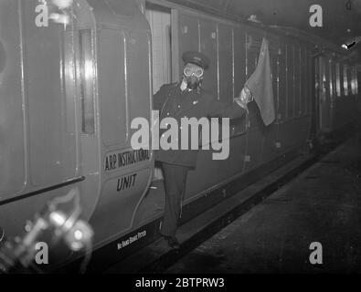 „bewacht“ gegen Gas. Anti Air RAID Training bei Euston. Und IMS Air RAID Vorsorge Mobile Instructional Unit war auf Euston Station, London, zu sehen. Die Einheit besteht aus zwei Fahrzeugen, einem Vortragswagen und dem anderen einem Dekontaminationswagen. Es wurde von der IMS Railway als Teil eines Programms zur Schulung ihrer Mitarbeiter in Air RAID Vorsichtsmaßnahmen zur Verfügung gestellt. Die mobile Einheit wird demnächst eine Tour durch das IMS-System in England, Schottland und Wales Unternehmen. Sie Eisenbahn beabsichtigt, fast 23,000 ihrer 230,000 Arbeiter in Anti-Luftangriffsarbeit auszubilden. Foto zeigt, ein Wächter in einer Gasmaske Markieren eines Zuges Stockfoto