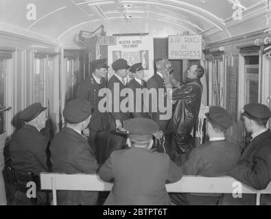 „bewacht“ gegen Gas. Anti Air RAID Training bei Euston. Und IMS Air RAID Vorsorge Mobile Instructional Unit war auf Euston Station, London, zu sehen. Die Einheit besteht aus zwei Fahrzeugen, einem Vortragswagen und dem anderen einem Dekontaminationswagen. Es wurde von der IMS Railway als Teil eines Programms zur Schulung ihrer Mitarbeiter in Air RAID Vorsichtsmaßnahmen zur Verfügung gestellt. Die mobile Einheit wird demnächst eine Tour durch das IMS-System in England, Schottland und Wales Unternehmen. Sie Eisenbahn beabsichtigt, fast 23,000 ihrer 230,000 Arbeiter in Anti-Luftangriffsarbeit auszubilden. Foto zeigt, Eisenbahner mit Gasmasken ausgestattet. A Stockfoto