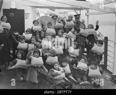 Rettungsschwimmer Parade! Seaforth Highlanders und Royal Artillery segelten von Southampton aus mit dem Troopschiff 'Dorsetshire' nach Hongkong und Singapur. Foto zeigt, Soldaten Kinder bereit für Rettungsgurt Inspektion. Dezember 1937 Stockfoto