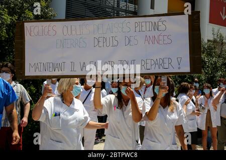 Krankenhauspersonal, das während der Demonstration eine riesige Plakette hält und Gesichtsmasken trägt, um vorsorglich gegen Covid 19 vorzugehen.Öffentliche Krankenhausmitarbeiter fordern bessere Arbeitsbedingungen und höhere Löhne. Stockfoto