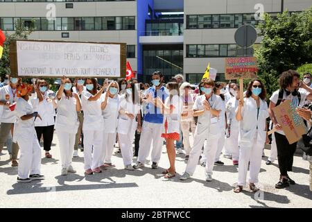 Krankenhauspersonal, das während der Demonstration eine riesige Plakette hält und Gesichtsmasken trägt, um vorsorglich gegen Covid 19 vorzugehen.Öffentliche Krankenhausmitarbeiter fordern bessere Arbeitsbedingungen und höhere Löhne. Stockfoto