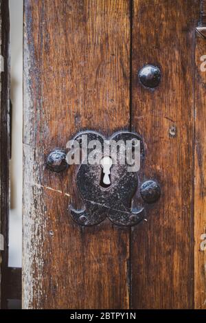 Vintage Schlüsselloch in rustikalem, mittelalterlichem Burgtor. Alte Holztür mit Eisenbeschlag. Retro-Stil Hand gefertigt Stahl dekorativen Schlüsselelement. Stockfoto