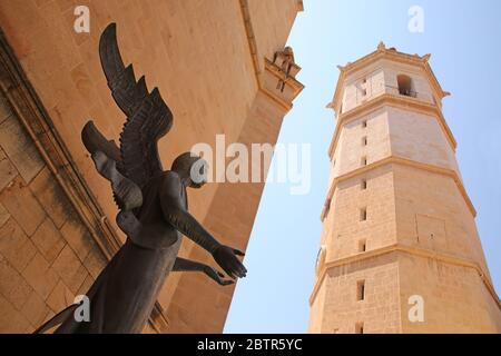 Statue eines Engels vor dem Hintergrund des historischen Glockenturms el fadri in der Stadt Castellón, Valencia, Spanien. Stockfoto