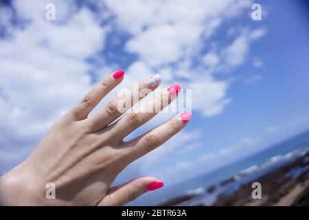 Frauenhand zeigt ihre halbpermanente Maniküre. Rosa Stockfoto