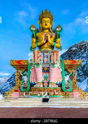 Goldene Maitreya Buddha in Ladakh Indien Statue sitzt in Schnee Berge im Diskit Kloster, Nubra Valley. Der Ort ist berühmt in Nubra Tal & Ladakh. Stockfoto