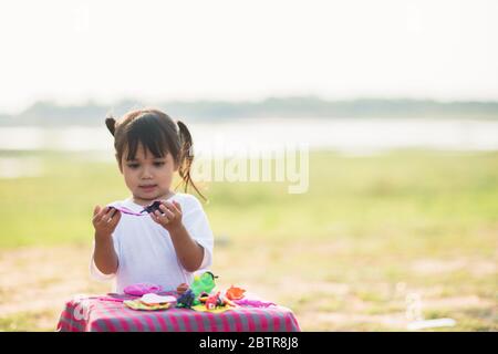Nettes kleines Mädchen genießen spielen doh im Park Stockfoto
