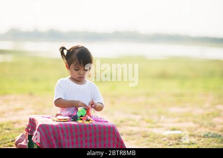 Nettes kleines Mädchen genießen spielen doh im Park Stockfoto