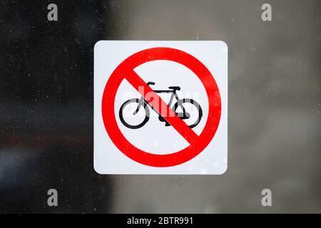 Rot mit weißem Aufkleber ohne Fahrradparkschild, auf einem schmutzigen Fenster. Fahrräder sind nicht erlaubt Stockfoto