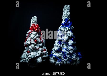 Geschmückte Schnee Weihnachtsbäume isoliert auf schwarzem Hintergrund Stockfoto
