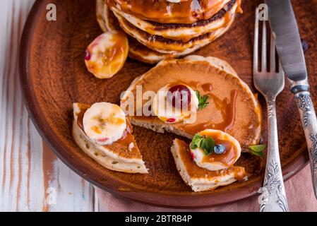 Köstliche und üppige Pfannkuchen mit frischen Früchten und Beeren, gefüllt mit gesalzenem Karamell. Leckeres Frühstück Stockfoto