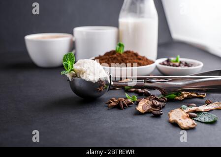 Champignon-Chaga-Kaffee Superfood Trend-Trockenpilze und frische Pilze und Kaffeebohnen auf dunklem Hintergrund mit Minze. Kaffeepause Stockfoto