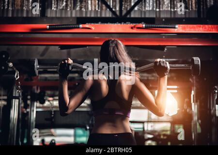 junge Fitness Frau führen Übung Übung-Maschine im Fitness-Studio Stockfoto