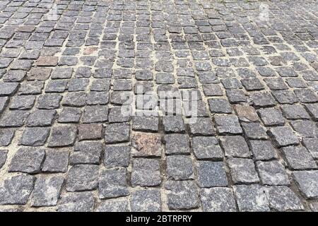 Grauer Pflasterstein, Hintergrund. Fußgängerzone im Park bei Tageslicht. Stadtplanung, Gehweg. Stockfoto