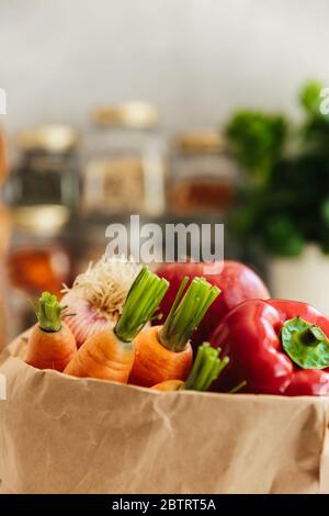 Papier Lebensmitteltasche mit Obst und Gemüse auf weißem Hintergrund, Öko-Shopping, Null Abfall, vegetarisches Konzept. Stockfoto