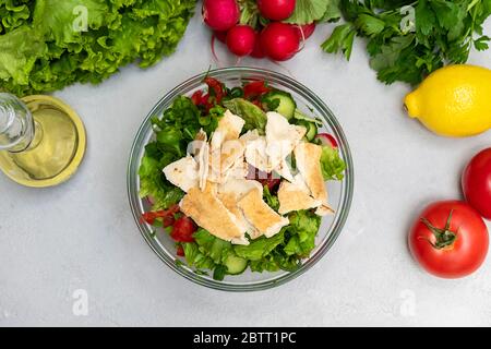 Draufsicht auf den Fattoush Salat in einer Schüssel mit Zutaten auf neutralem Hintergrund Stockfoto