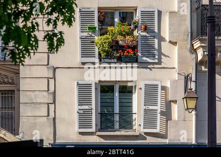 Paris, Frankreich - 14. Mai 2020: Fenster mit Blumen in einem pariser Haus Stockfoto