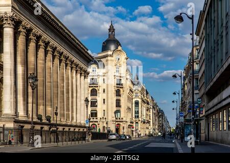 Paris, Frankreich - 14. Mai 2020: Haussmann-Gebäude in der Straße Reumur und Säule des Palais Brongnard im Vordergrund in Paris Stockfoto