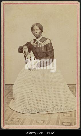 Cartedevisite Porträt von Harriet Tubman. Ein Carte-de-Visite von Harriet Tubman in einem Innenraum Raum. Sie ist leicht nach rechts gedreht positioniert und blickt von der Kamera. Ihre rechte Hand liegt auf dem Rücken eines Holzstuhls und ihre linke Hand liegt in ihrem Schoß. Stockfoto